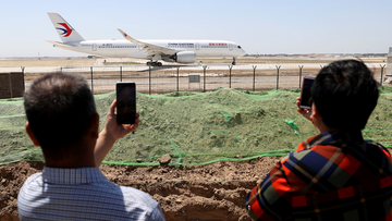 Residents watch as a China Eastern passenger jet prepares to take off on a test flight from the new Beijing Daxing International Airport on Monday, May 13, 2019.