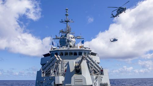 HMAS Ballarats embarked MH-60R helicopter flies in formation with a United State Navy MH-60R, off the coast of Queensland, during Exercise Talisman Sabre 2021.