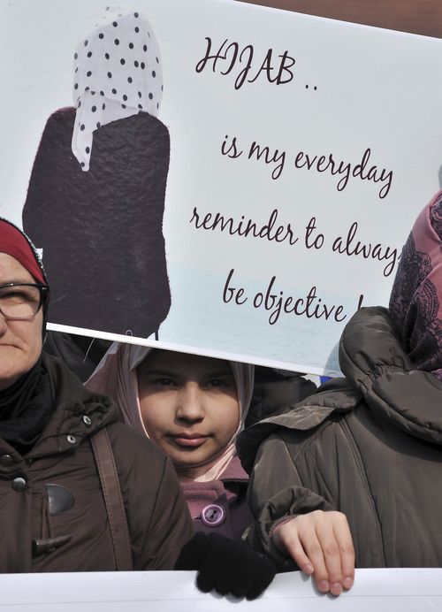 A girl holds a sign during a protest against the ban of Islamic headscarves in judicial institutions in Bosnia and Herzegovina. (AFP)