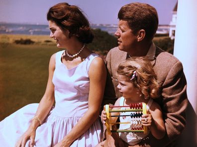 Senator John F. Kennedy relaxes w/ his wife Jacqueline and daughter Caroline.