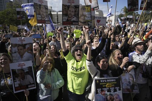 People holding posters with photos of Israelis hostages Eli Sharabi, Or Levy and Ohad Ben Ami