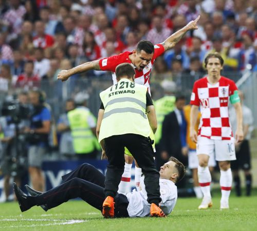 Dejan Lovren (top) of Croatia yells at an intruder (bottom) during the second half of the World Cup final against France at Luzhniki Stadium in Moscow on July 15, 2018. Russian protest group and musical act Pussy Riot has claimed responsibility for the incident. (Kyodo via AP Images)