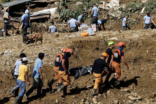 Rescuers carry a body they recovered at the site where victims are believed to have been buried by a landslide after Typhoon Mangkhut lashed Itogon, Benguet province, northern Philippines.