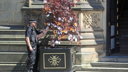 Police officers read messages left on a 'Tree of Hope'. (AAP)