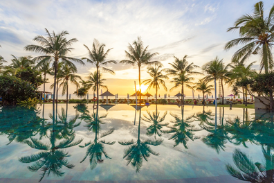 Sunrise view at the pool with palm trees at Ayodya Resort, Nusa Dua, Bali.  
