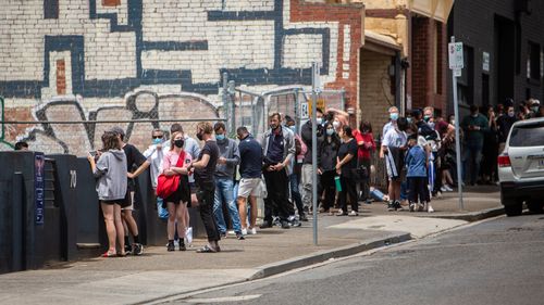 Des gens font la queue devant le site de test COVID sur Alfred Street à North Melbourne.