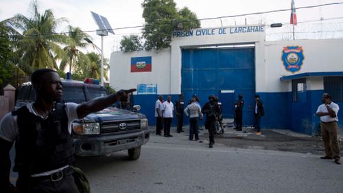 Police gather at the Civil Prison after some inmates escaped in the coastal town of Arcahaiea, Haiti. (AAP)