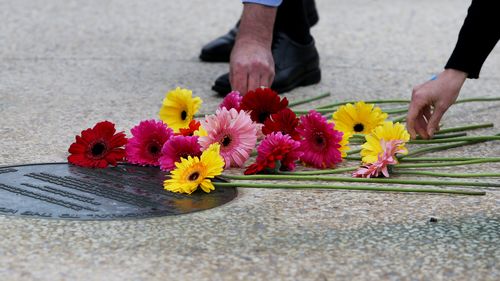 Family and community members lay flowers and pay their respects at this year's Bali Bombings memorial. 