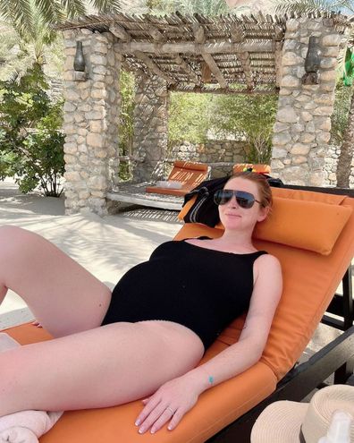 Lindsay Lohan poses pregnant by the pool. 