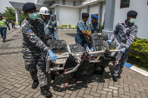 Members of the Indonesian Navy carry wreckage recovered from the Java Sea of AirAsia flight QZ8501 upon its arrival at Juanda military airport in Surabaya. (Getty)