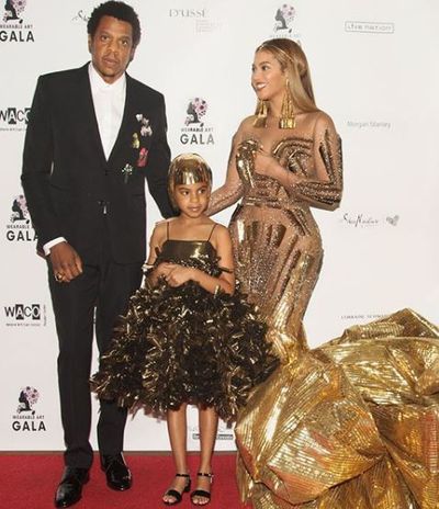 Blue Ivy in a custom gold feathered dress and headpiece from Annakiki at the Wearable Art Gala last month in New York with parents Jay Z and Beyoncé.