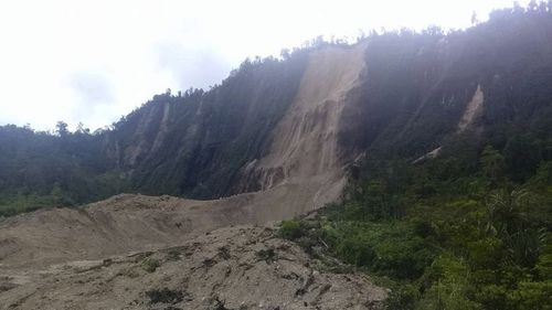 In this Monday, Feb. 26, 2018, photo, debris from a massive landslide from Monday's earthquake covers an area in Tabubil township, Papua New Guinea. The 7.5 magnitude powerful earthquake in Papua New Guinea is hindering efforts to assess the destruction, although officials fear dozens of people may have been injured or killed. (Luke Purre via AP