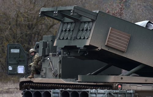 A US soldier sits at a Multiple Launch Rocket System (MLRS) during the demonstration of the reload procedures after an artillery live fire event by the US Army Europe's 41st Field Artillery Brigade at the military training area in Grafenwoehr, southern Germany, on March 4, 2020.  