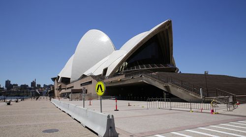 Sydney’s Opera House looking almost completely deserted under a picture perfect blue sky.