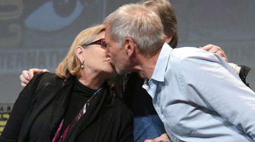 Fisher and Ford share a kiss in front of crowds at Comic-Con International. (Getty)