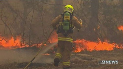 A firefighter struggles to control an out-of-control blaze.