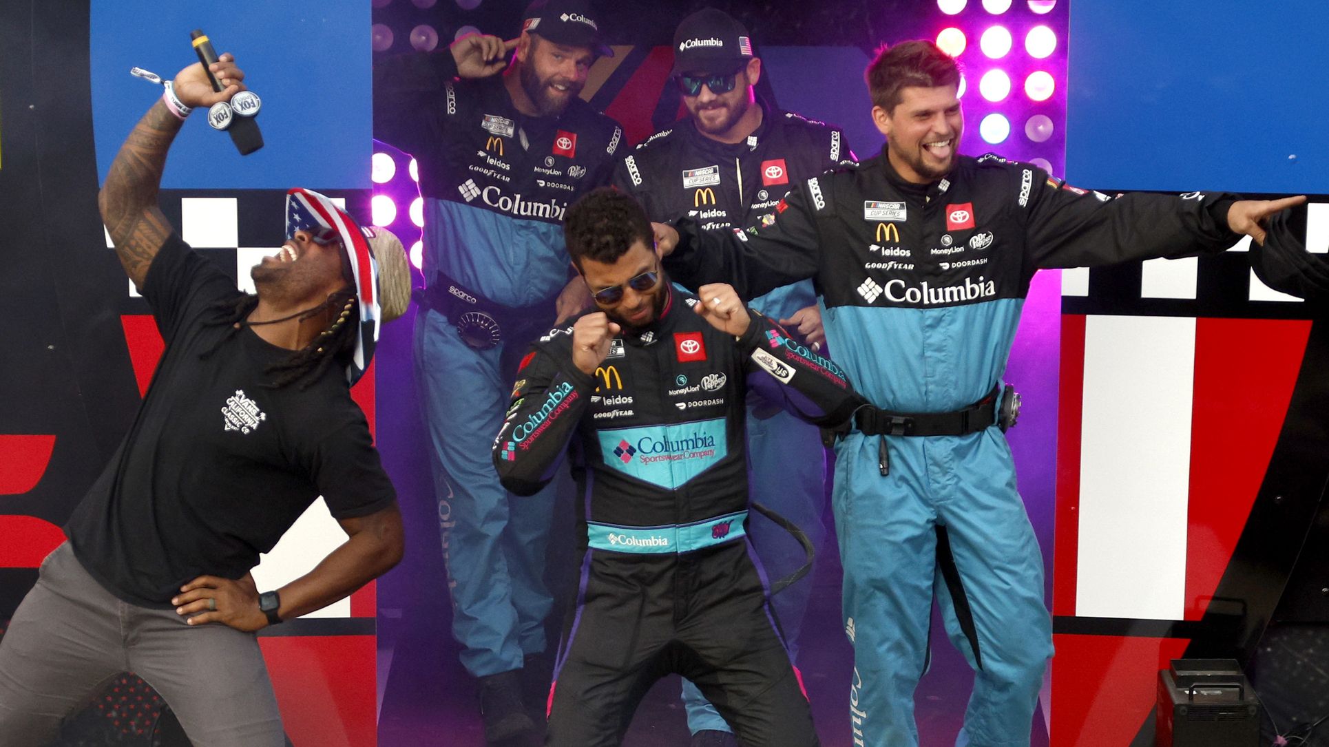 Bubba Wallace walks onstage during driver intros prior to the NASCAR Cup Series All-Star Race at North Wilkesboro Speedway, seemingly mocking fans.