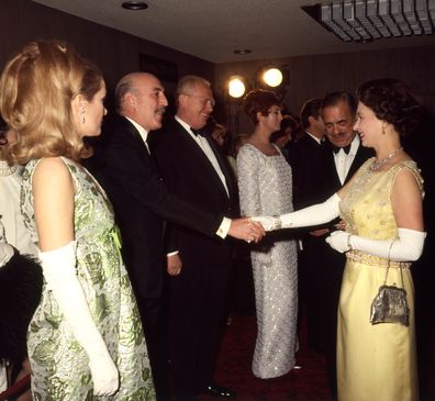 Queen Elizabeth shaking hands with Lionel Jeffries, watched by Sally Ann Howes (both stars of the film), at the Royal world premiere of the film 'Chitty Chitty Bang Bang' 