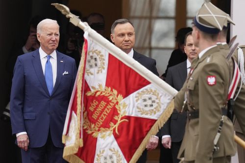 US President Joe Biden, left, and Polish President Andrzej Duda, center, attend a military welcome ceremony at the Presidential Palace in Warsaw, Poland, on Saturday, March 26, 2022 