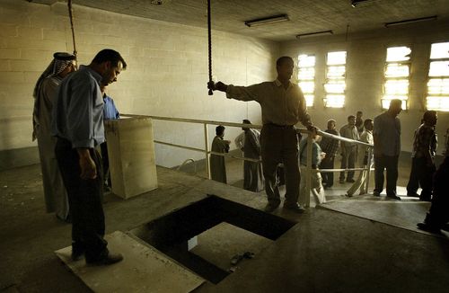     Uomini iracheni si riuniscono sul patibolo nella prigione di Abu Ghraib, Baghdad, Iraq. 14 aprile 2003. 