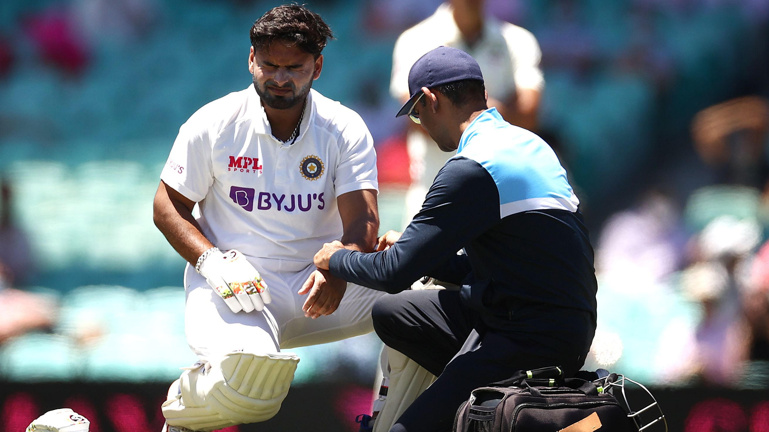 Rishabh Pant of India reacts after being struck by a delivery from Pat Cummins of Australia.