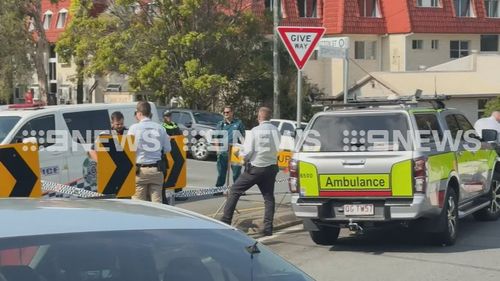 QLD Ambulances and emergency services standing in a street.