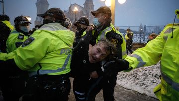 A man is arrested by police as protestors and supporters gather as a protest against COVID-19 measures that has grown into a broader anti-government protest continues to occupy downtown Ottawa on Thursday, Feb. 17, 2022. 