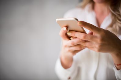 Close up of a woman using her smartphone indoors.