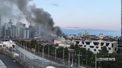 Multiple fire crews are battling to control a factory fire that has caused thick black smoke to billow out over the Melbourne CBD.