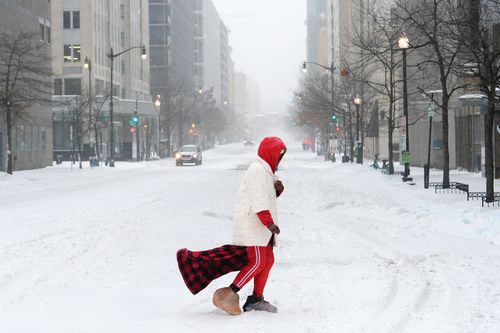 Uma pessoa atravessa uma rua durante uma tempestade de neve, domingo, 25 de janeiro de 2026, em Washington. (Foto AP/Julia Demaree Nikhinson)