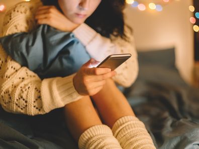 Girl texting on smartphone at home