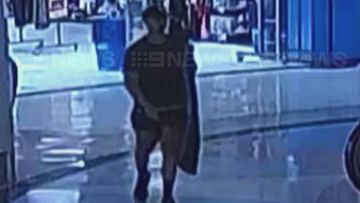 CCTV of Beau Lamarre-Condon walking out of a shop with a surfboard bag.