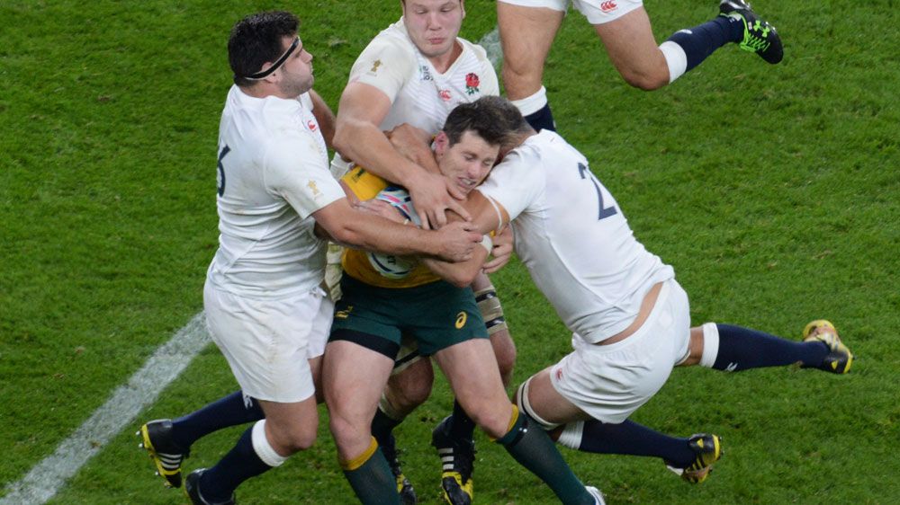 Bernard Foley is tackled by England players the last time the two teams met. (AFP)