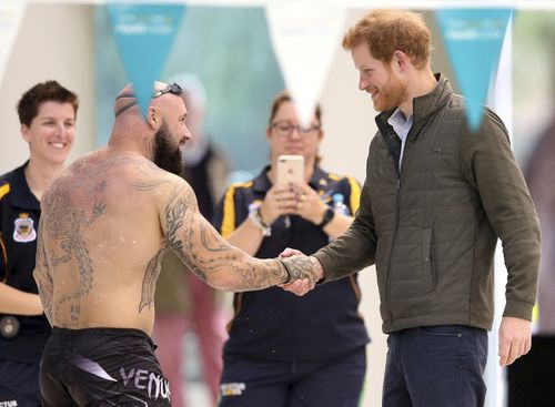 Prince Harry, right, shakes hands with an athlete during a demonstration at the the Aquatic Centre. (AAP)