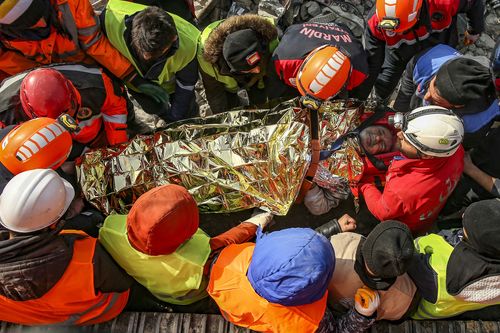 Turkish rescue workers carry Eyup Ak, 60, to an ambulance after pulling him out alive from a collapsed building, 104 hours after the earthquake, in Adiyaman, Friday, Feb. 10, 2023. 