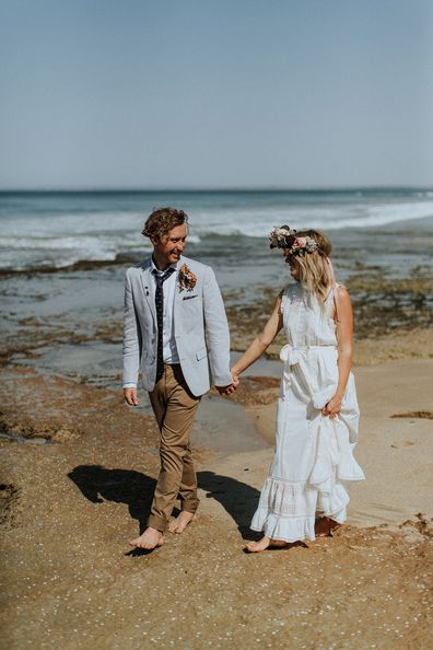 Australian bride and groom surf together before beach wedding