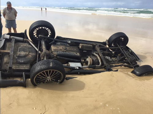 By the time the recovery team were able to access the Range Rover, only its tires and underside were visible about the sand. (Queensland Ambulance Service)