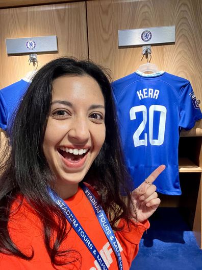 Karishma Sarkari in Stamford Bridge Stadium dressing room, pointing at Sam Kerr's Chelsea jersey
