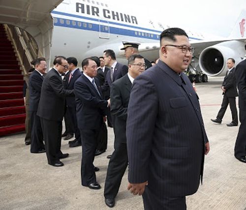 In this photo released by the Ministry of Communications and Information of Singapore, North Korean leader Kim Jong Un, right, arrives at the Changi International Airport.