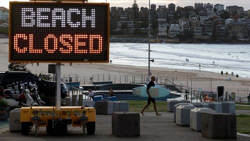 This April photo shows a sign at Bondi Beach as a surfer arrives at the Sydney beach.