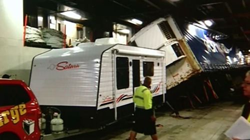A semi-trailer on the ship's vehicle deck crushed cars when it tipped on its side.