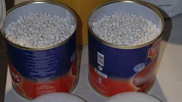 In this photo supplied by the Australian Customs Service, two tins disguised as canned tomato, holding thousands of ecstasy tablets are seen at a warehouse in Melbourne, Australia, Friday, Aug. 8, 2008.