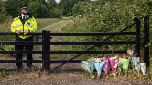 Flower tributes at an entrance to Fryent Country Park, in north London, where a murder investigation has been launched following the deaths of two sisters, Monday June 8, 2020. (Dominic Lipinski/PA via AP)