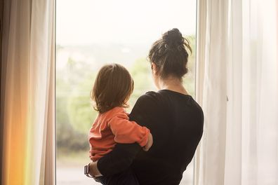 Mother and son looking out of window