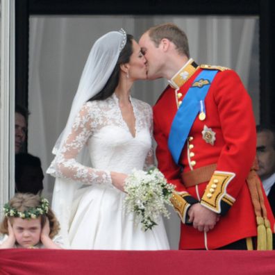 Prince William, Duke of Cambridge and Catherine, Duchess of Cambridge kiss next to Grace Van Cutsem (L) and Margarita Armstrong-Jones on the balcony at Buckingham Palace on April 29, 2011 in London, England