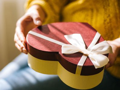 Young woman holding valentine day gift box