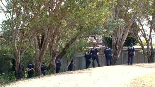 Officers searched neighbouring lawns following the grim discovery. (9NEWS)