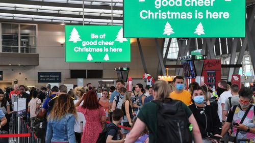 SYDNEY, AUSTRALIA - DECEMBER 18: Airline passengers wait in line to check in at Sydney's Kingsford Smith domestic airport on December 18, 2020 in Sydney, Australia. A cluster of Covid-19 cases on the northern beaches of Sydney has grown to 28, prompting NSW health officials to urge residents of affected suburbs to stay home. Traffic at Sydney Airport has increased as people rush to leave the city with several states imposing quarantine restrictions for New South Wales residents. (Photo by James 