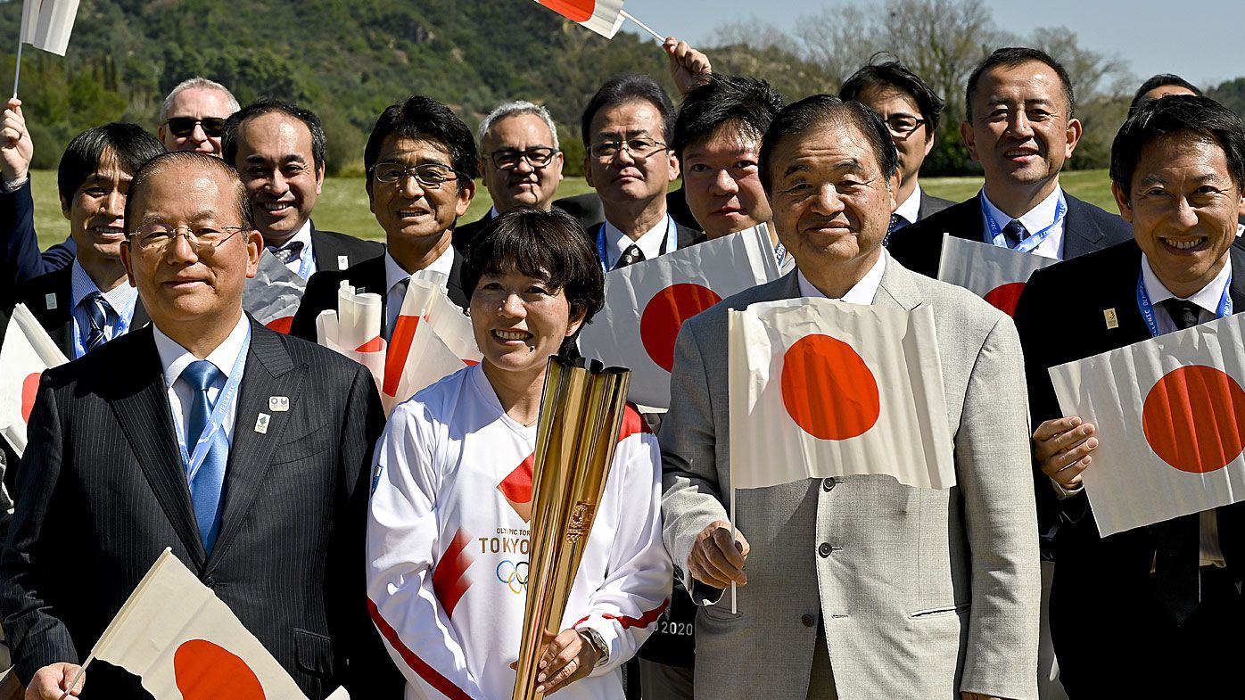 Japanese former marathon runner Noguchi Mizuki and president of the Tokyo 2020 Organising Committee Toshiaki Endo pose for a picture following the Olympic flame lighting ceremony 