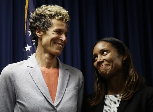 Accuser Andrea Constand, left, reacts at a news conference with prosecutor Kristen Feden.